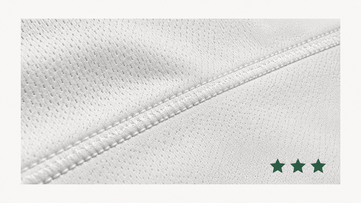 Gros plan sur la maille technique et la couture d'un maillot de foot avec une note trois étoiles